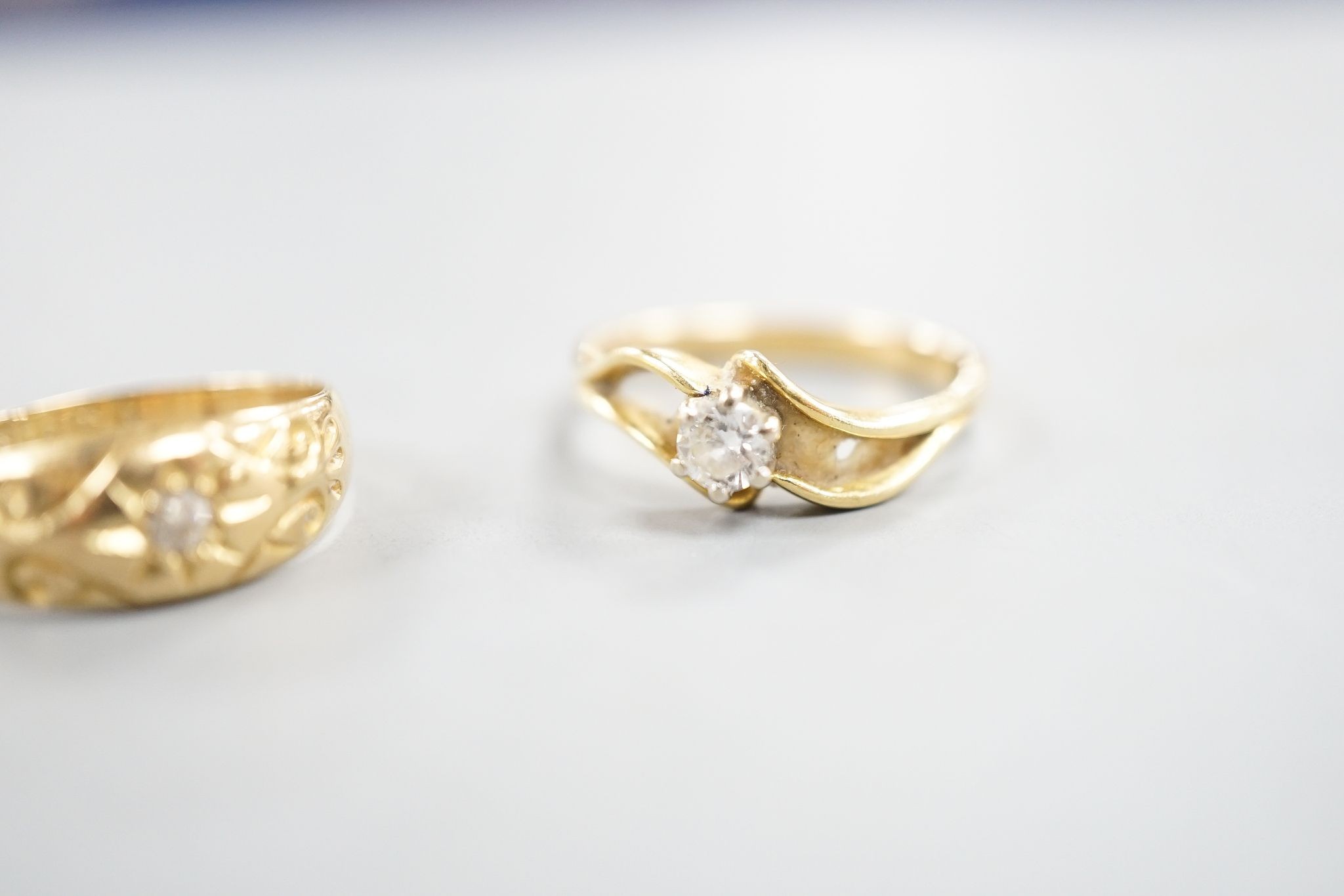 A George V 18ct gold and diamond chip set ring, size O and a later 750 yellow metal and solitaire diamond ring, size P, gross weight 5.9 grams.
